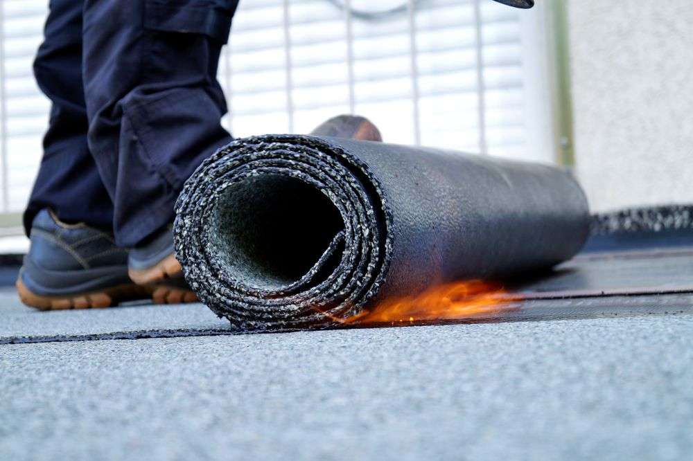 Dakspecialist met bitumen rol